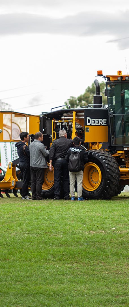 Visitors inspecting a road grader at the Australian Construction Equipment Expo